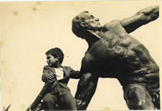 Close up of child sitting on a large figurative sculpture