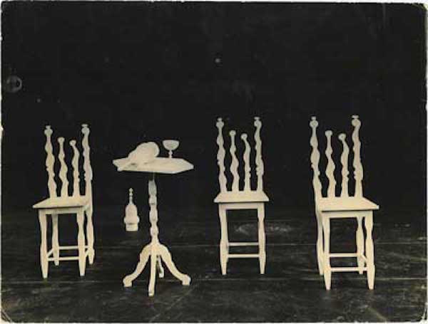 Stage design of three white sculptural chairs and small table