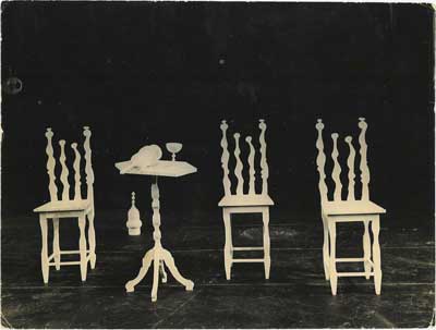 Stage design of three white sculptural chairs and small table