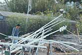 Multiple vertical poles on sawhorses with people in background