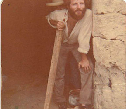 Slobodan standing in a doorway with piece of lumber